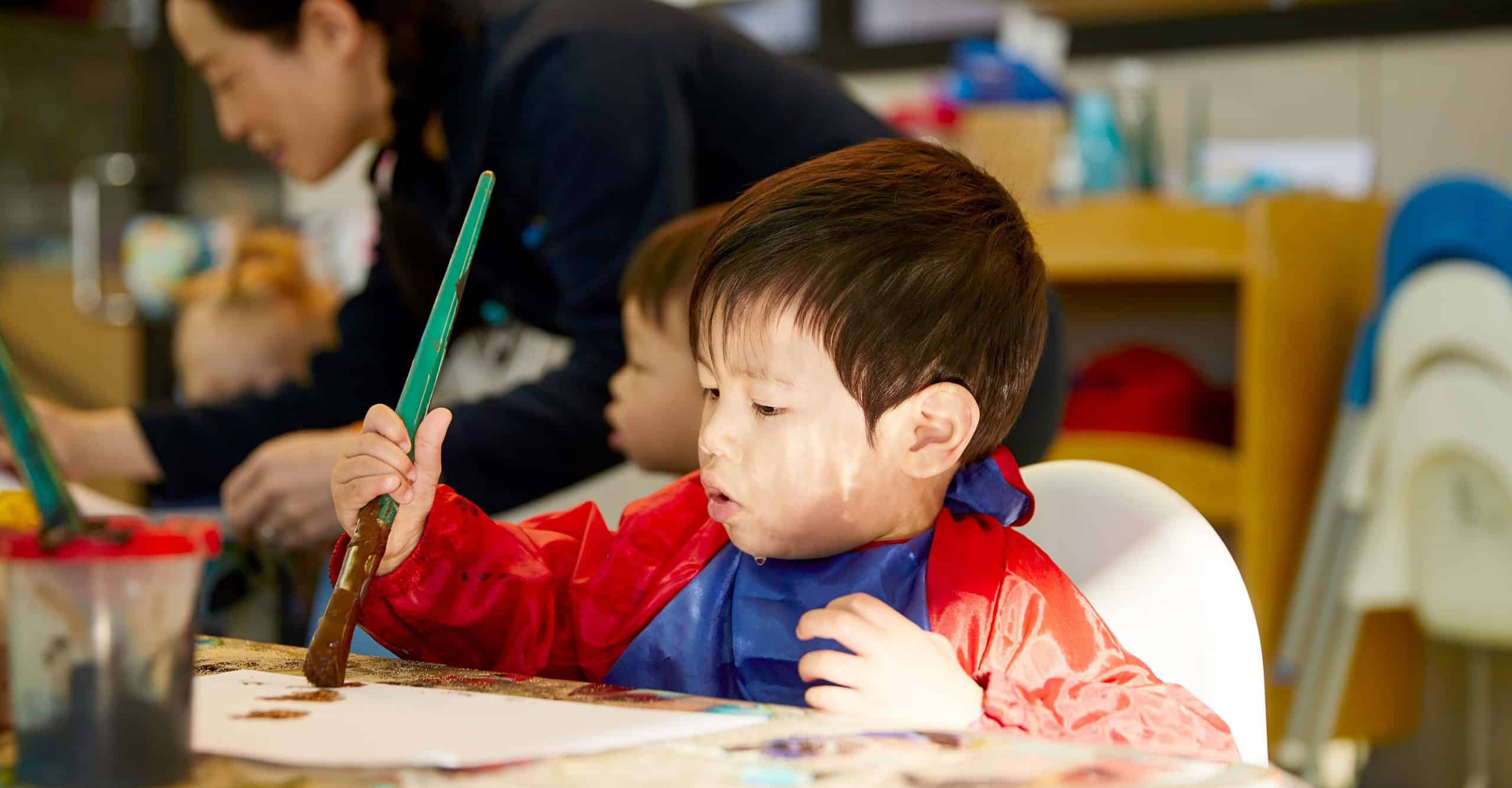 A child painting creatively at Kindalin Castle HIll